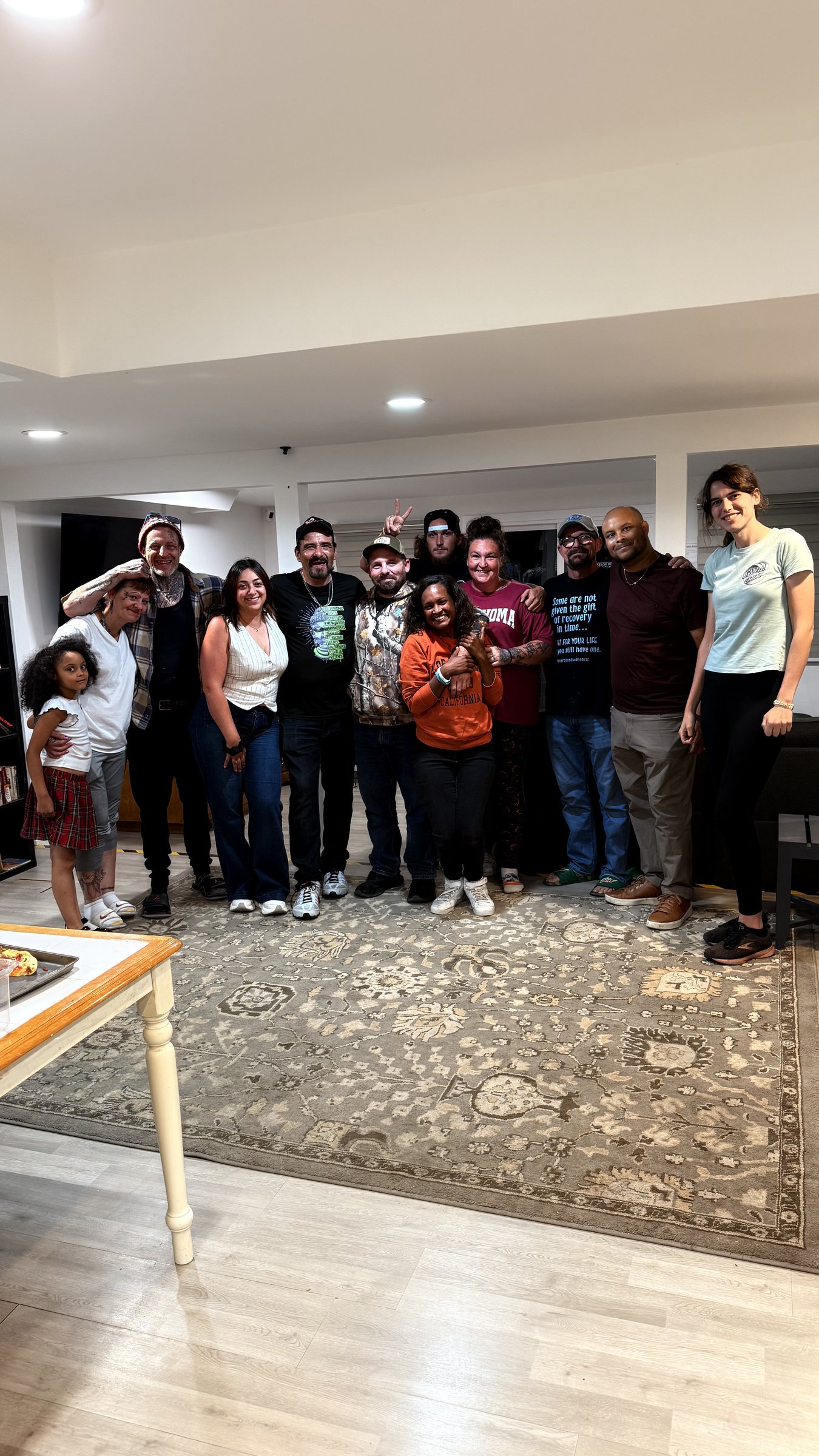 Lumen Collective residents and family gathered together in the living room at a house celebration